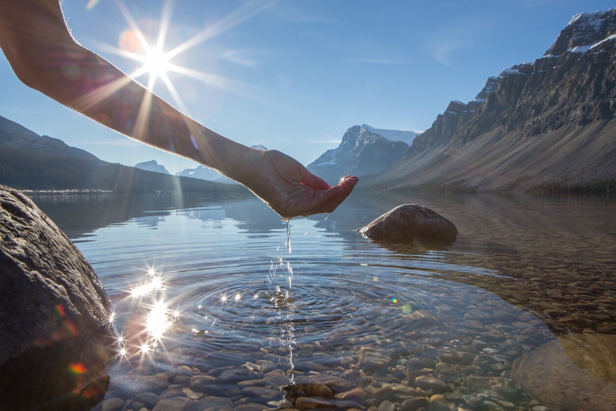 Human hand cupped to catch the fresh water from lake stock photo. jenniferanistonbody.com