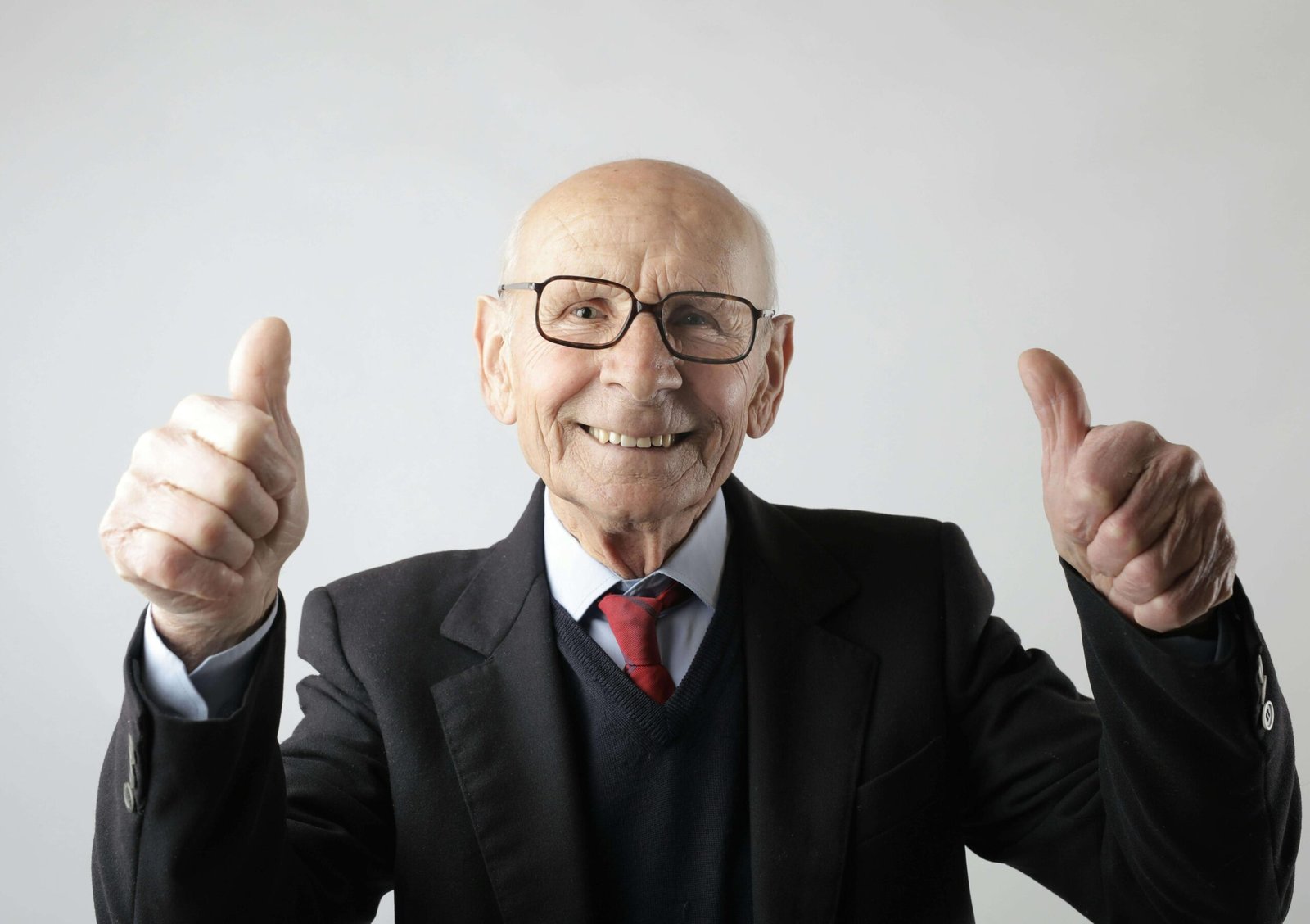 Positive senior man in eyeglasses showing thumbs up and looking at camera. jenniferanistonbody.com