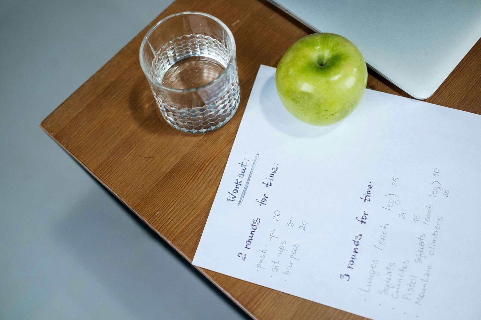 Green Apple and Glass of Water on the Wooden Table. jenniferanistonbody.com